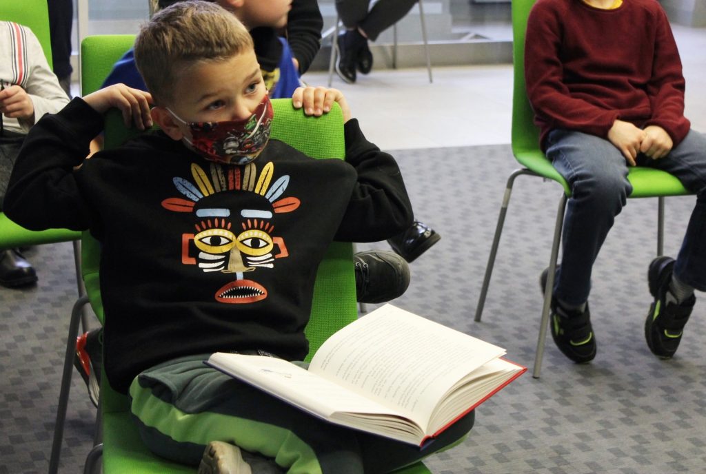 Dziecko podczas spotkania z otwartą książką na kolanach