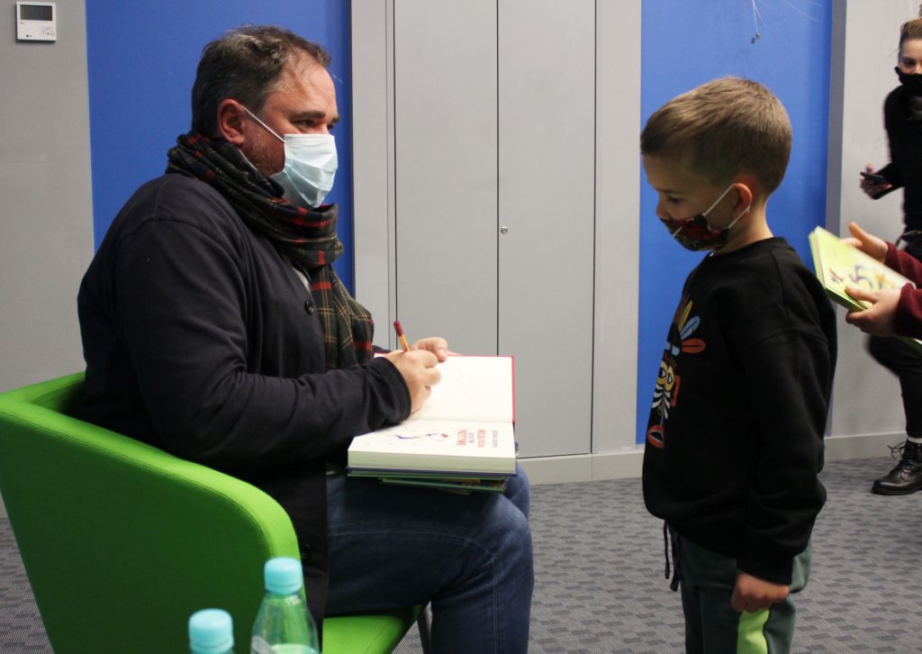 Chłopiec bierze autograf od autora