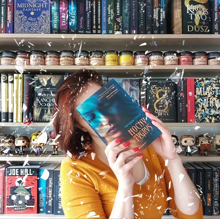 dziewczyna z książką na tle biblioteczki