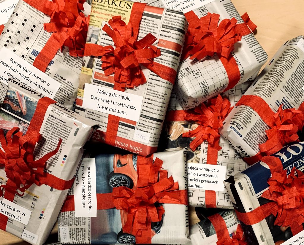 książki zapakowane w papier obwiązane czerwoną wstążką