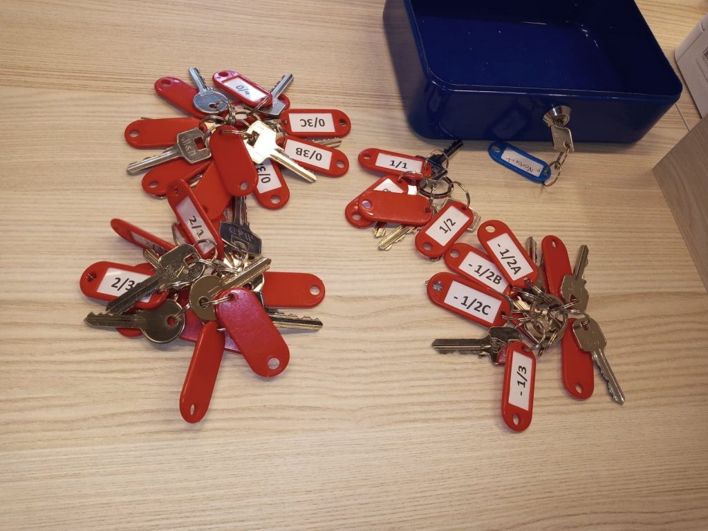 pęki kluczy z breloczkami leżące na blacie