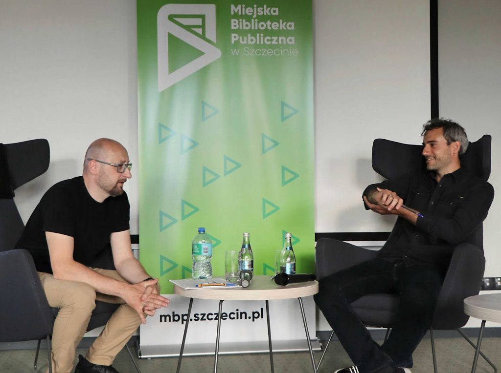 Dwóch mężczyzn na tle roll upu MBP