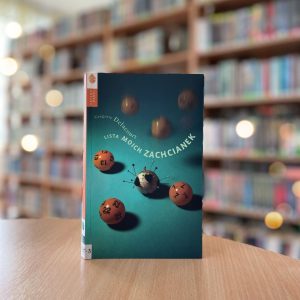 okładka książki Lista moich zachcianek Gregoire’a Delacourta na tle regałów z książkami